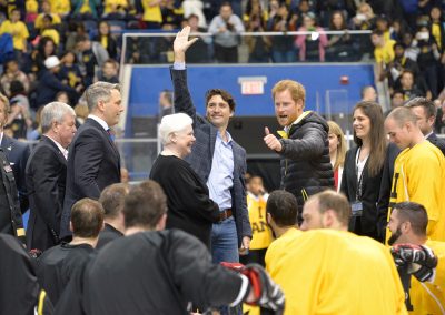 Prime Minister Justin Trudeau waves to fans, Prince Harry gives a thumbs-up to the team