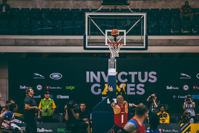 Player throws basketball from three-point line / Un joueur lance le ballon depuis la ligne de trois points